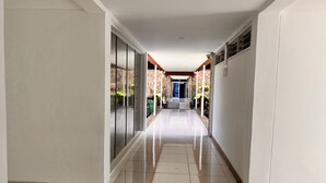 A long, narrow hallway with a tiled floor and glass doors on one side. - Tom Mboya Labour College (Kisumu)