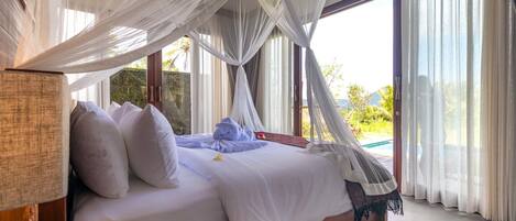 Un dormitorio con cama con dosel, vistas al exterior y una piscina.