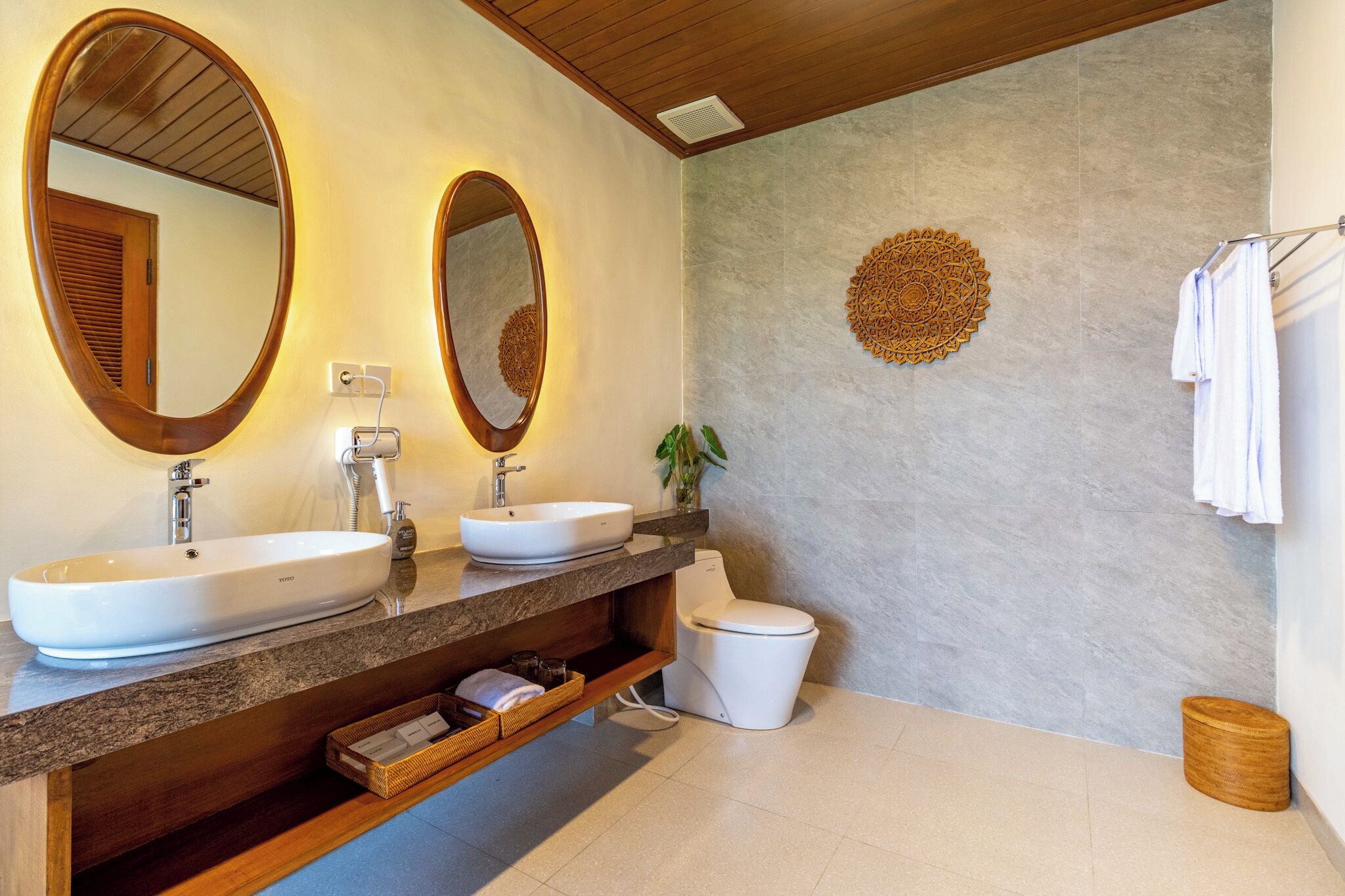 Un bagno con due lavandini, un water e uno specchio.