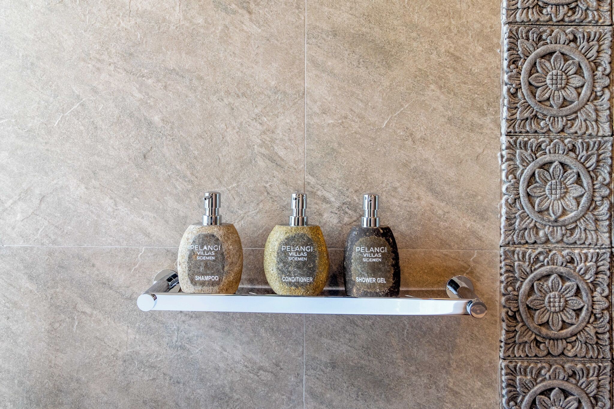 Estante de baño con tres artículos de aseo: champú, acondicionador y gel de ducha.