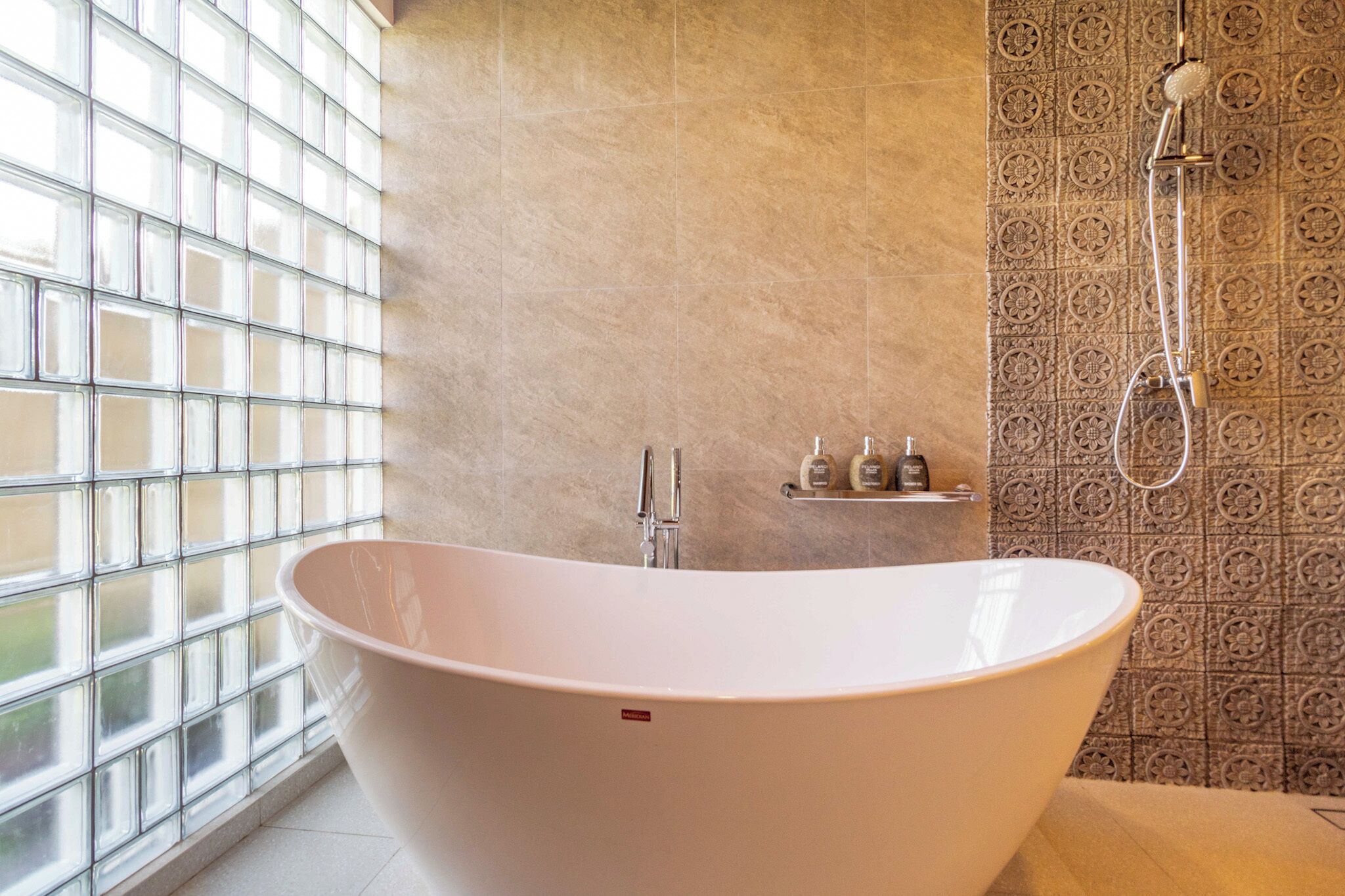 Une salle de bain moderne avec une baignoire sur pieds, une douche et une fenêtre à motifs géométriques.