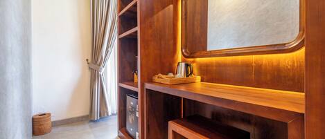 Une pièce en bois avec un bureau intégré, un miroir et un petit coin salon.