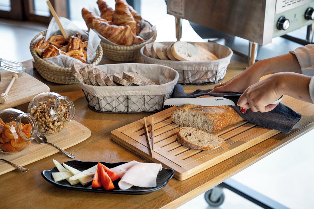 Un plan de travail de cuisine avec divers aliments, notamment du pain, du fromage et une planche à découper.
