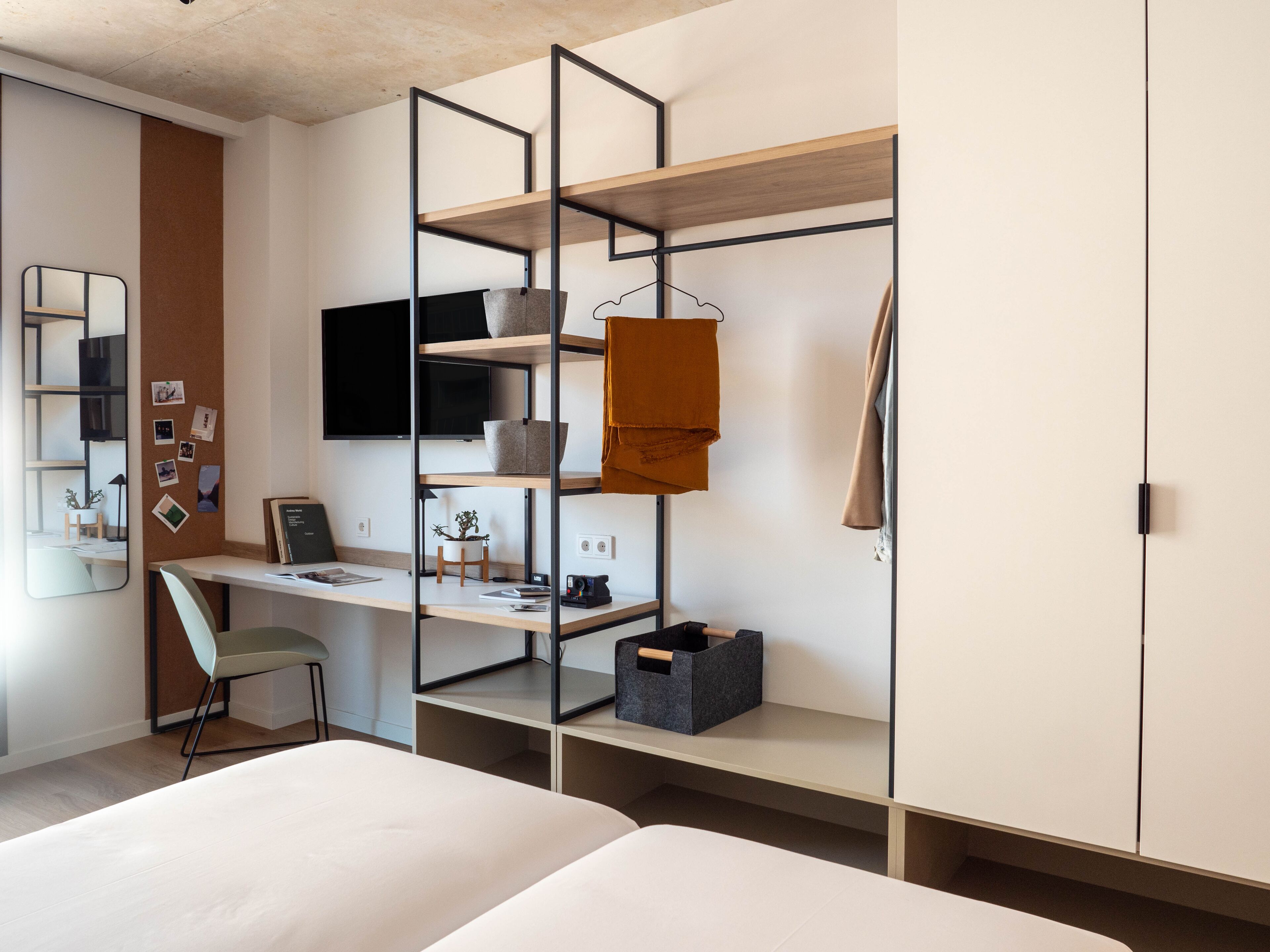 A modern bedroom with a desk, a bed, and a wardrobe.