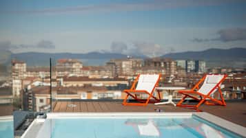 Relax by the rooftop pool overlooking the city and mountains.