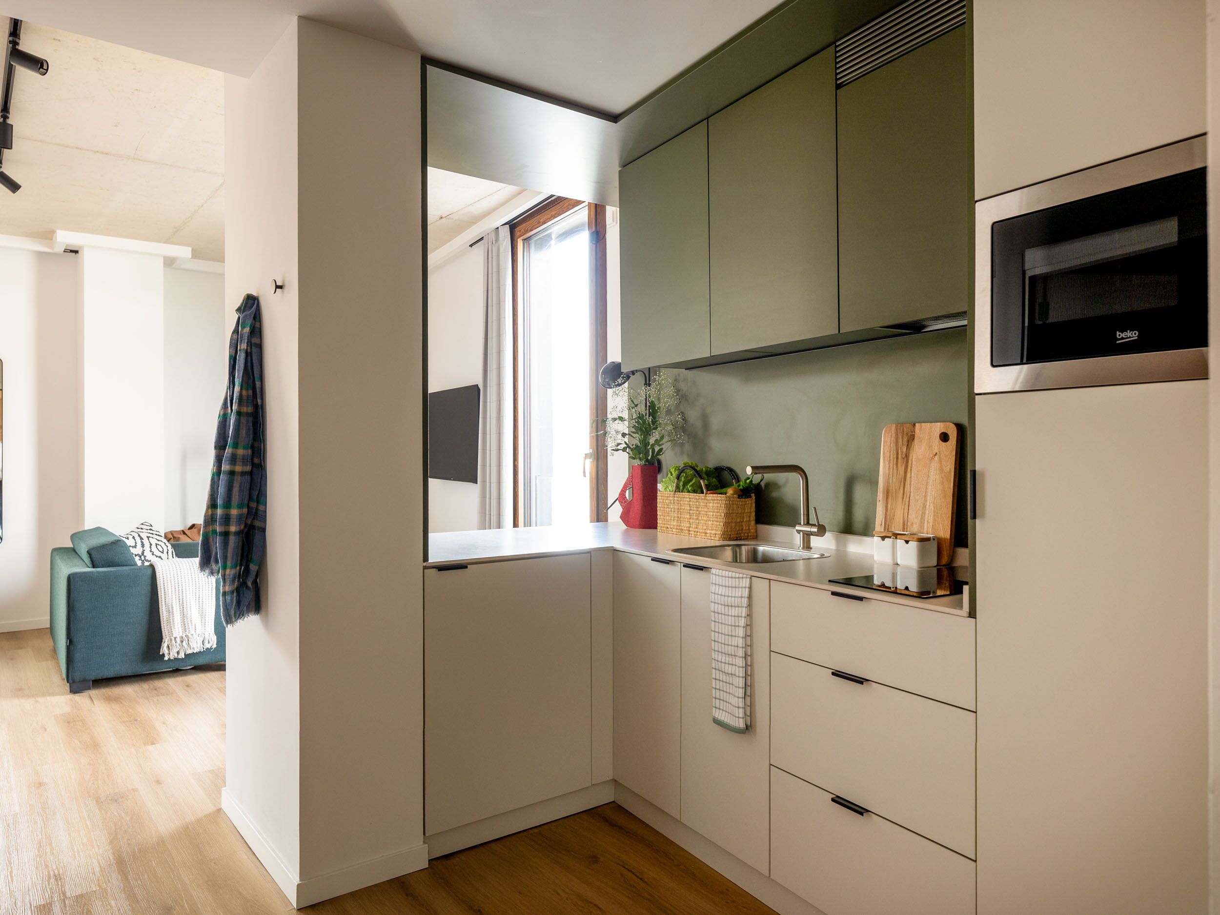 Una cocina moderna con microondas integrado, un fregadero y una ventana.