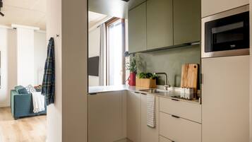 Una cocina moderna con microondas integrado, un fregadero y una ventana.
