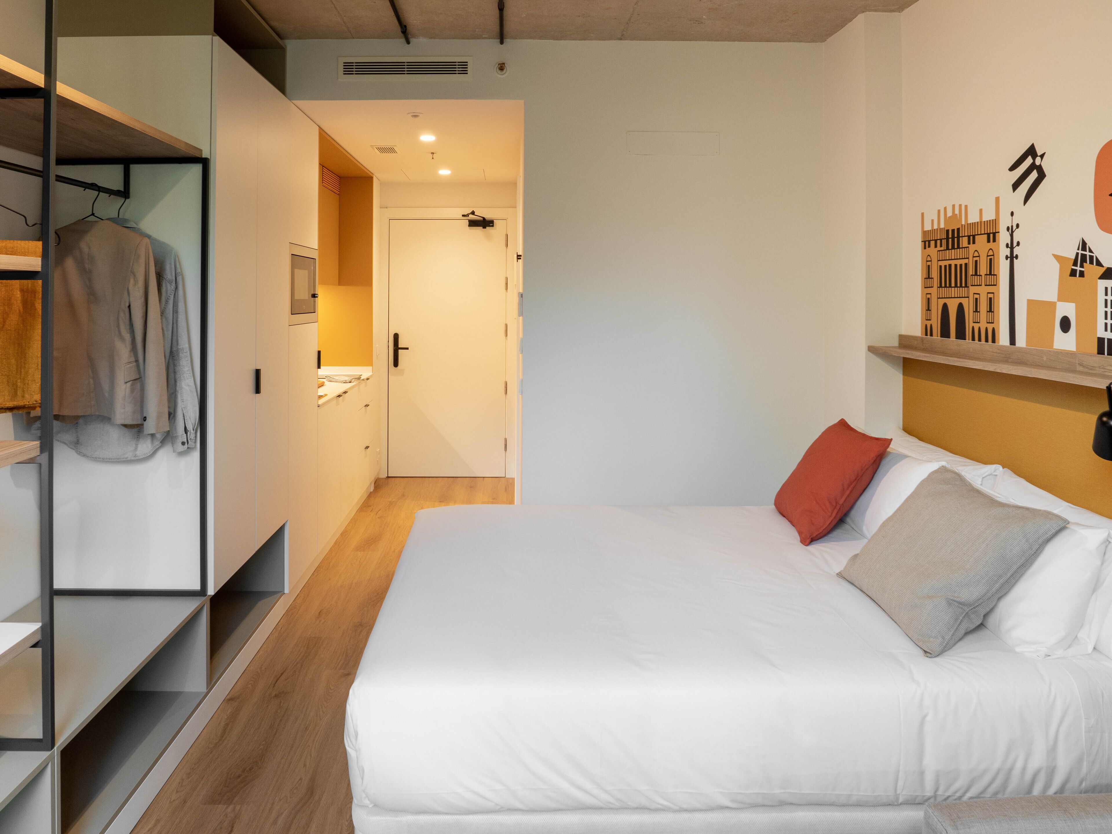 Un dormitorio con cama, armario y un pasillo que da a un baño.