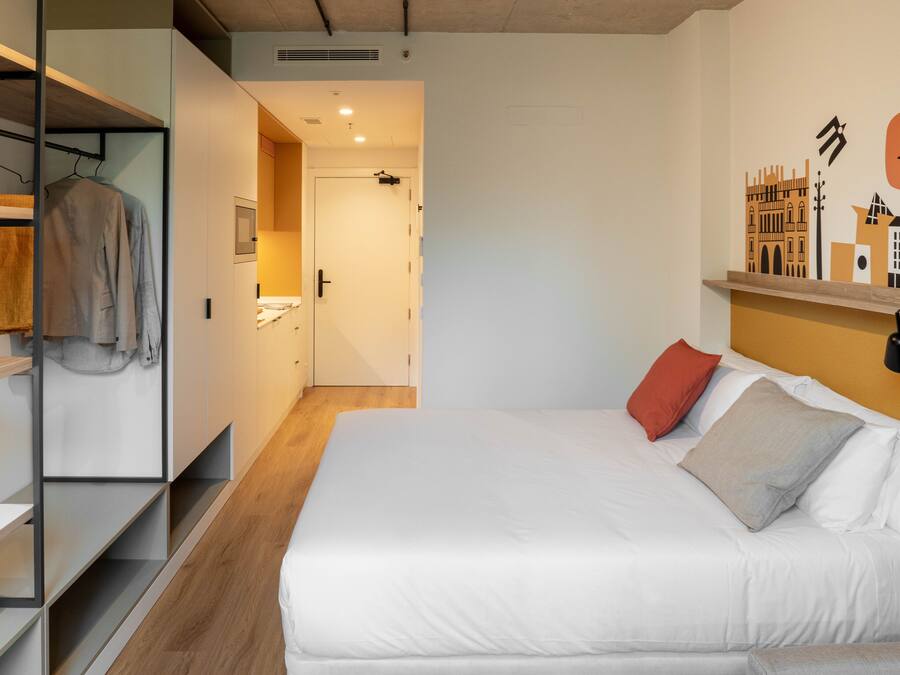 Un dormitorio con cama, armario y un pasillo que da a un baño.