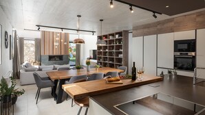 Eine moderne Küche mit Kochinsel, integriertem Backofen und Essbereich mit Holztisch und Stühlen.
