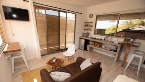 Een moderne woonkamer met een bank, salontafel en een aan de muur bevestigde televisie.