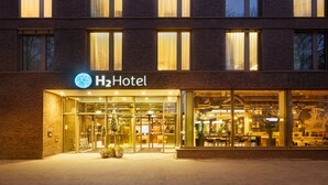 A hotel entrance with a glass facade, a sign reading "H2Hotel", and a visible reception area inside. - H2 Hotel Mainz (Mainz)