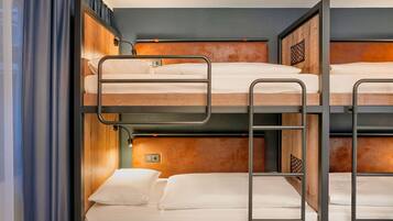 Una camera con un letto a castello, una testiera in legno, una luce notturna e una tenda.