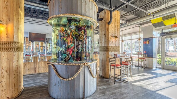 Relax in a contemporary space with a stunning cylindrical aquarium and seating areas for dining or lounging.