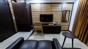 A modern living room with a sofa, a TV, a wooden cabinet, and a small table. - Alpha-Plus Apartments 91 Utako (Abuja)