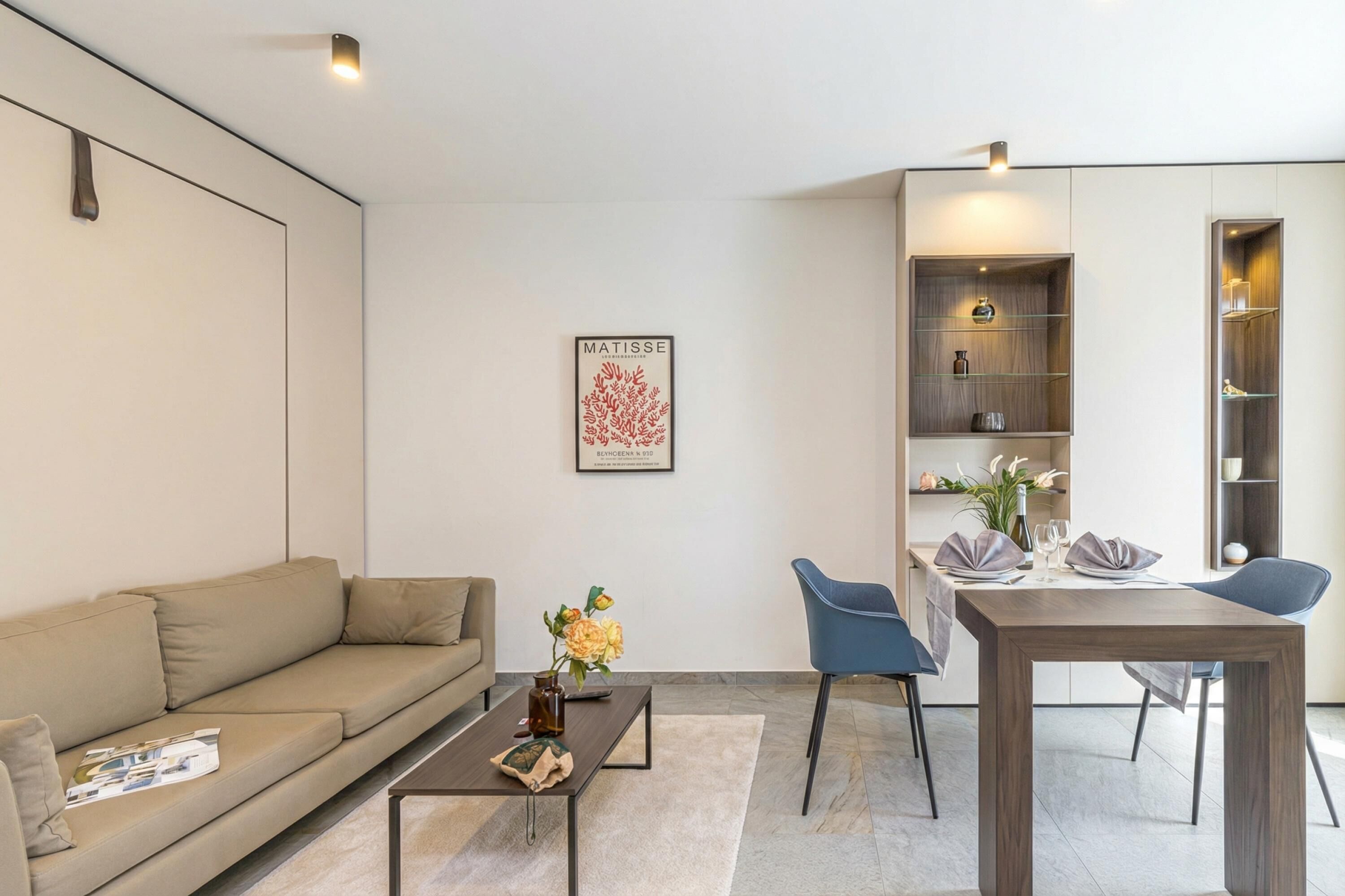Una sala moderna con sofá, mesa de centro y comedor con mesa y sillas.