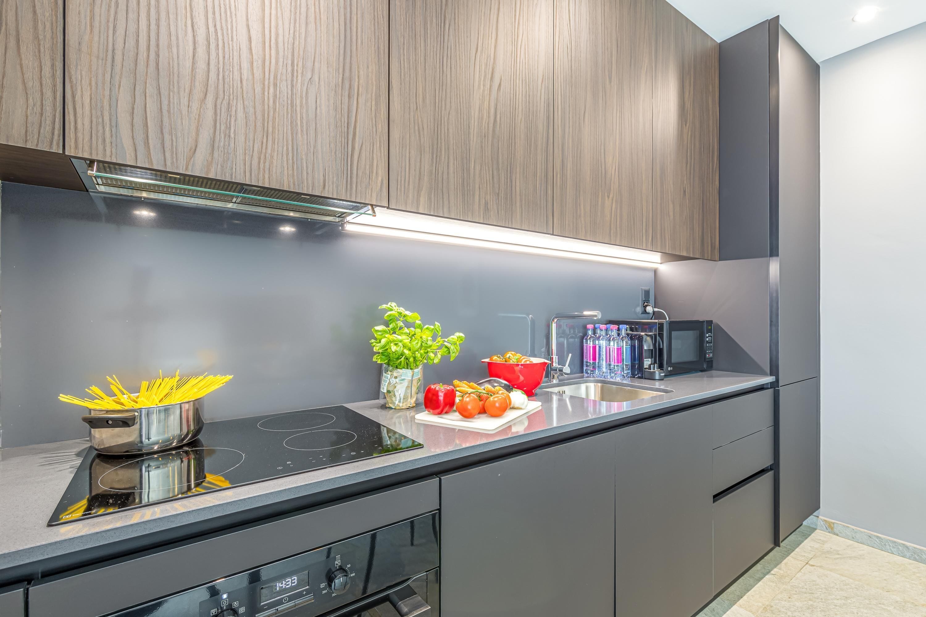 A modern kitchen with a built-in stove, microwave, and stainless steel appliances.