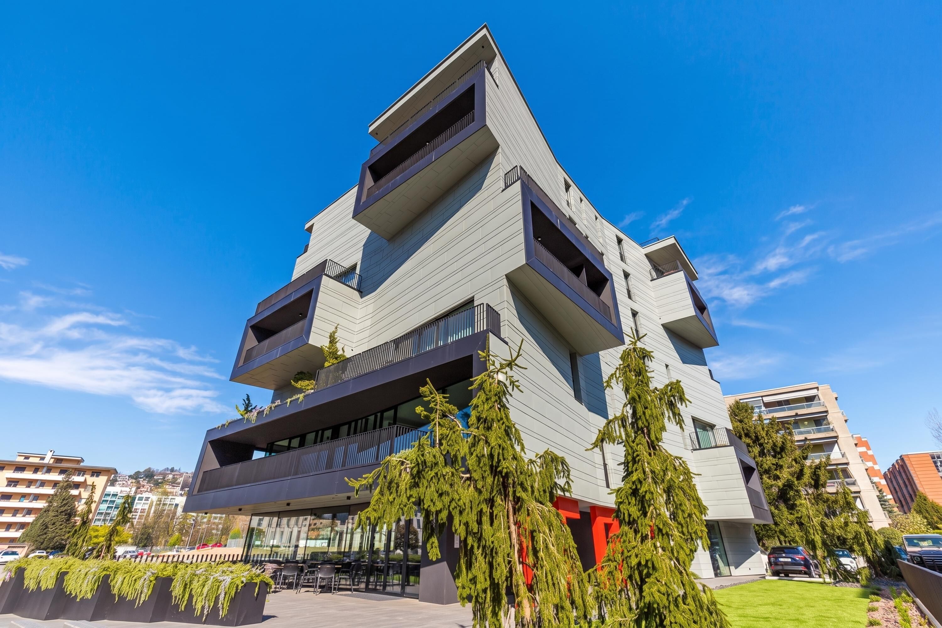 Un moderno edificio a più piani con balconi, tetto piano e cielo sereno.