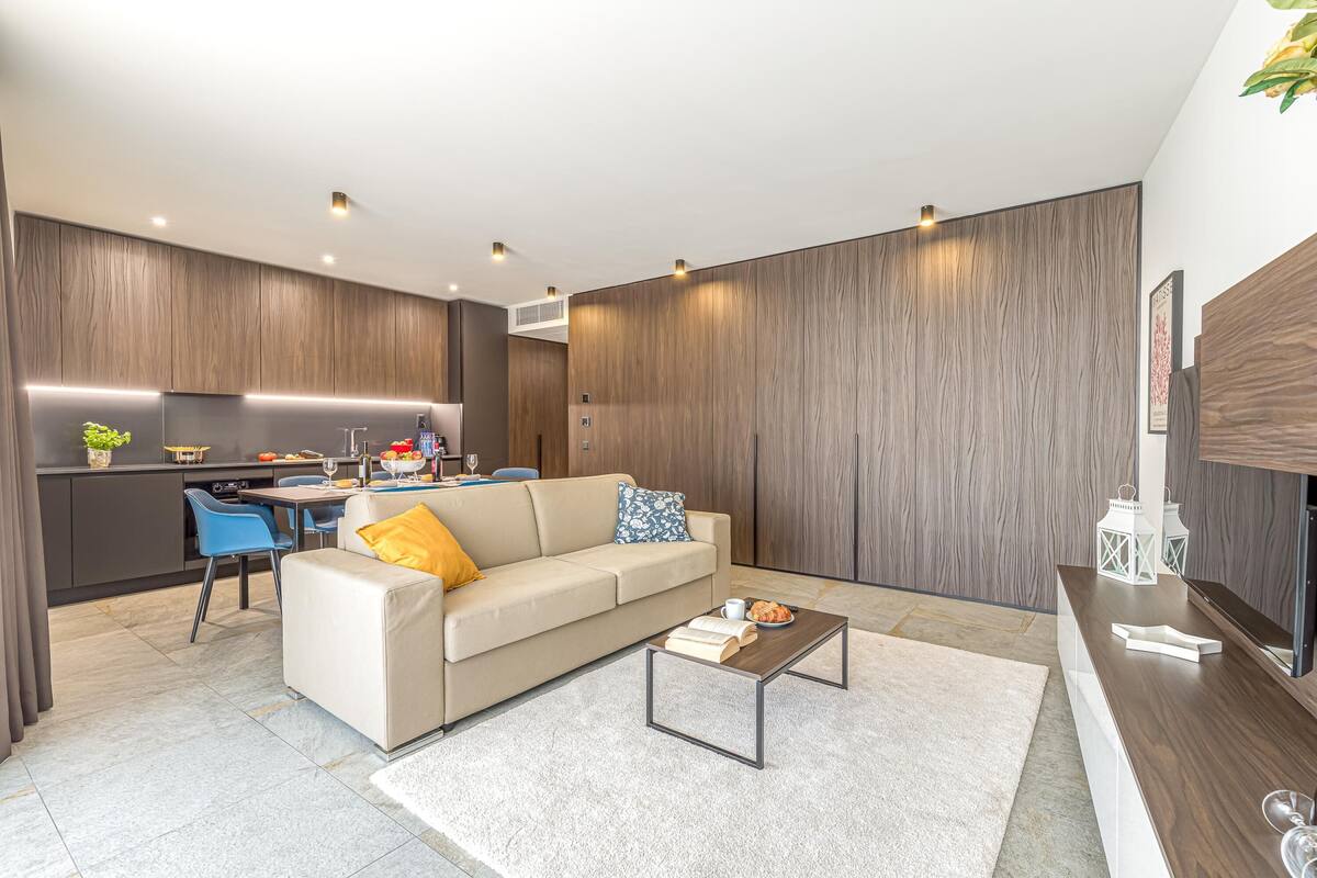 A modern living room with a sofa, coffee table, and a TV stand.