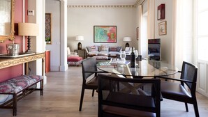 Amplia sala de estar con una mesa de centro de vidrio, asientos cómodos y vistas al comedor contiguo.