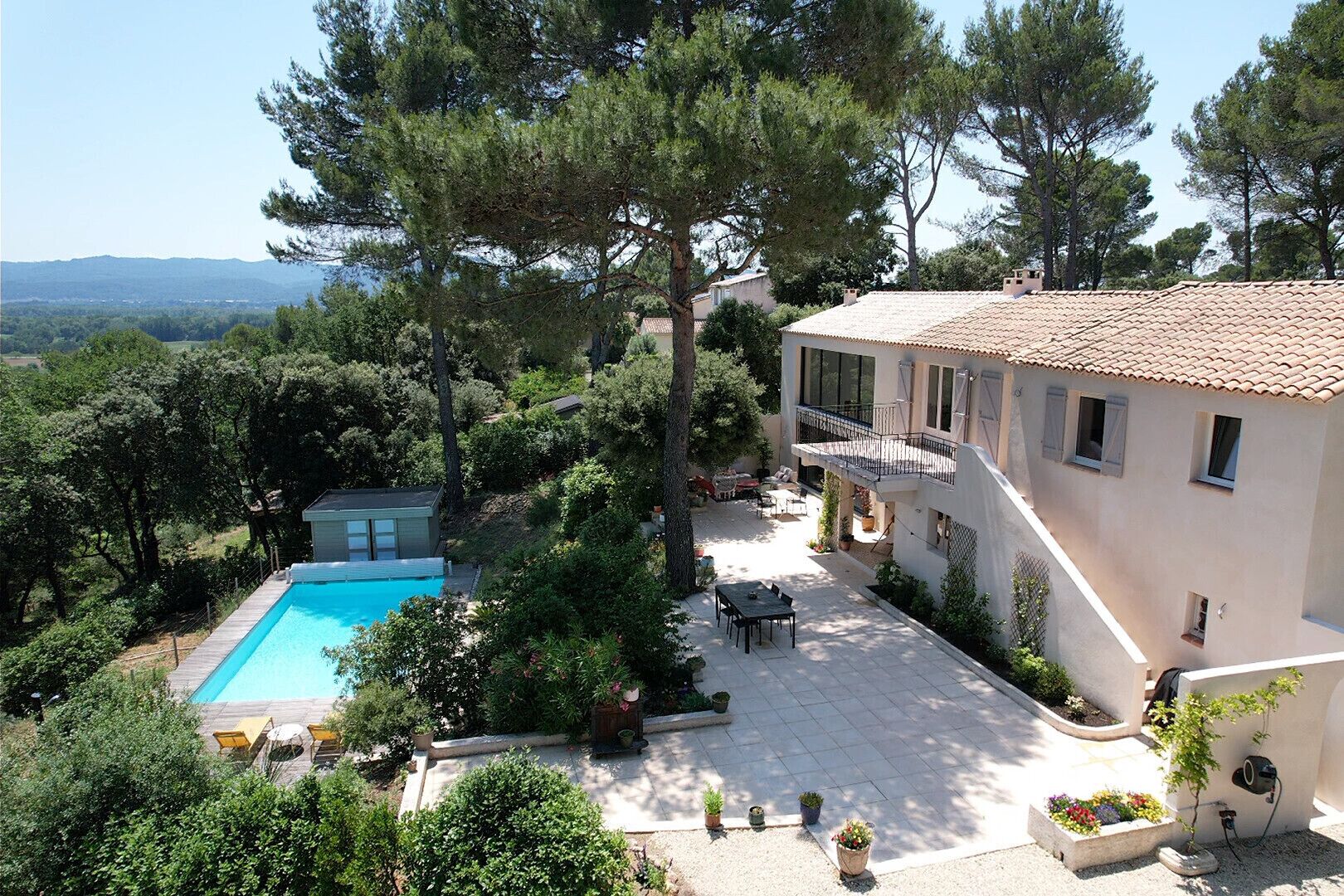 A villa with a swimming pool, outdoor seating, and a garden.