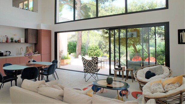 Un espacio habitable moderno con cocina, comedor y zona de estar, con ventanas amplias.