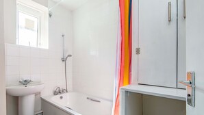 Une salle de bain avec une baignoire, un lavabo et une douche.