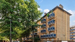 Un immeuble résidentiel à plusieurs étages, doté de balcons et d’une façade en briques.