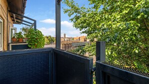 Un balcon offrant une vue sur le paysage urbain, avec notamment un pont et des immeubles.