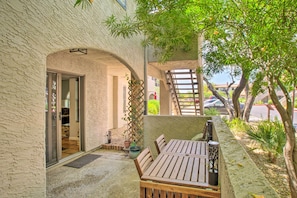 Enjoy dining or socializing in this patio area with a wooden table and chairs.