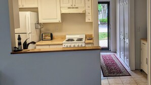 A compact kitchen with white cabinets, a stove, and a toaster. - DAPHNE -  MOBILE BAY CONDO - Great location  (Daphne)
