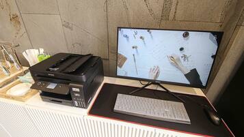 Un'area di lavoro con stampante, tastiera e monitor che mostra un documento con firme.
