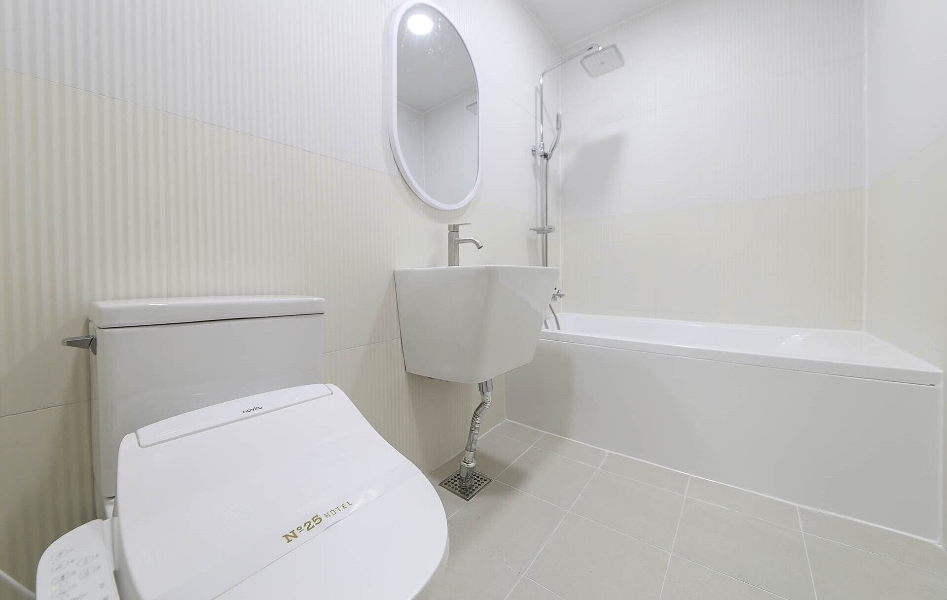 A modern bathroom with a toilet, sink, and bathtub.