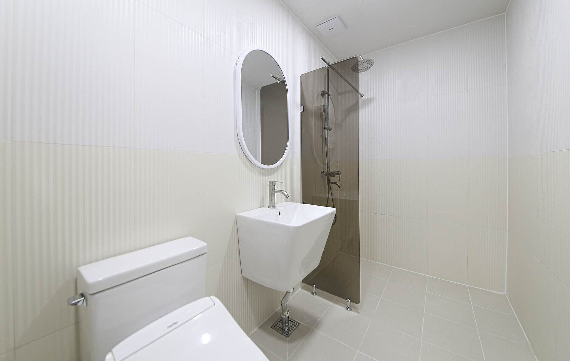 Une salle de bain moderne équipée de toilettes, d’un lavabo et d’une douche.