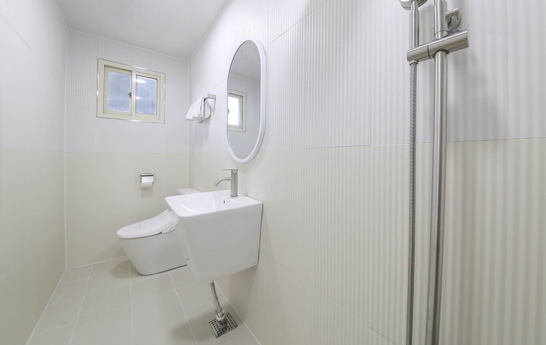 Un baño moderno con inodoro, lavamanos y ducha.