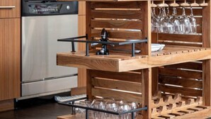 Eine Küche mit Holzschränken, einem Edelstahlkühlschrank, einem Weinkühler und einer Kaffeemaschine.
