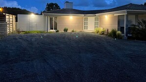 Een modern huis met een overdekte patio, een garage en een keurig onderhouden oprit.