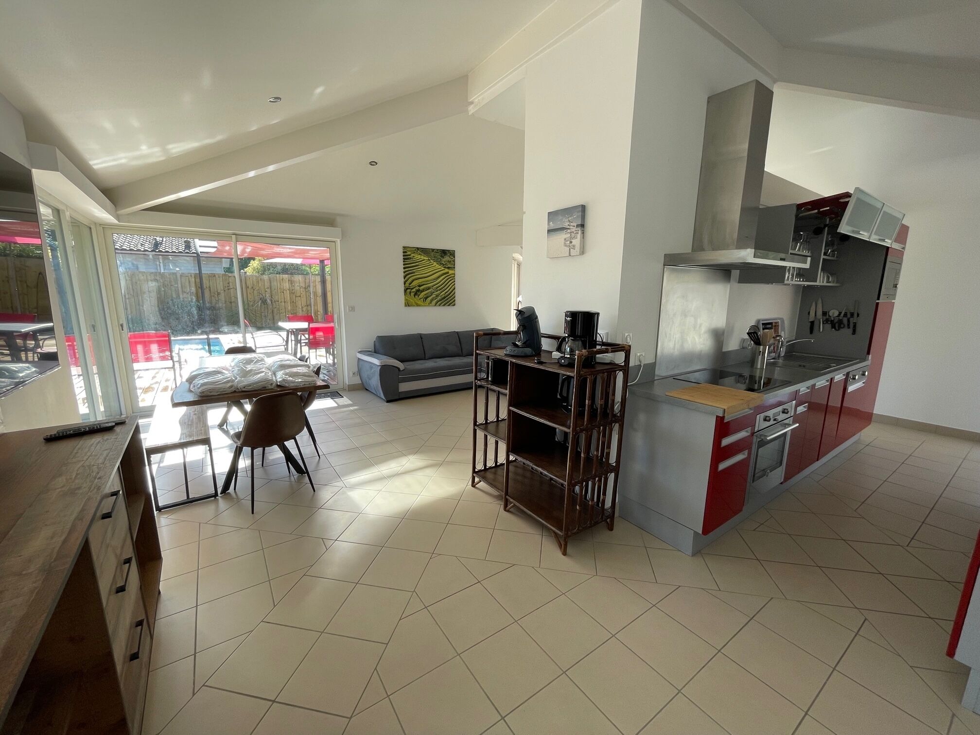 Een ruime keuken met een eethoek, een bank en uitzicht door grote glazen schuifdeuren.