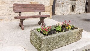 A stone bench with a planter box containing flowers. - Haddon Cottage (Bakewell)