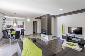 Relax in a stylish living space with a dining area, sofa, and flat-screen TV.