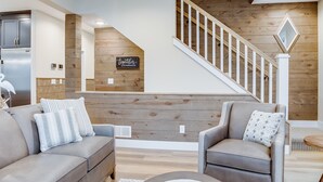 Una sala de estar moderna con una escalera de madera, una zona de cocina y un letrero que dice "juntos".