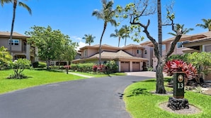 A residential area with a paved driveway leading to a row of houses with multiple garages. - Colony Villas At Waikoloa Beach Resort #1305 3 Bedroom Villa by RedAwning (Waikoloa)