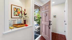 A hallway with a wooden bowl, a framed painting, and a welcome sign. - Colony Villas At Waikoloa Beach Resort #1305 3 Bedroom Villa by RedAwning (Waikoloa)