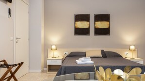 A modern bedroom with a bed, bedside lamps, a chair, and artwork on the wall. - Residence Bonomelli apt. no. 15 studio apartment (Bergamo)