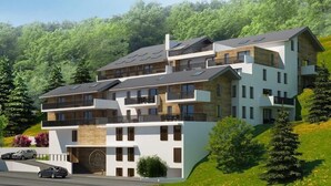 Un edificio de varios pisos con balcones, un garaje y una entrada para vehículos.