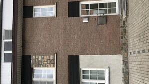 A top-down view of a building with three windows, each with shutters, and a stone wall section. - Cozy Vacation Home for 8 Persons in Heers (Heers)