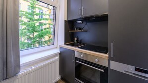 A compact kitchen with a built-in oven, a stovetop, and a refrigerator.