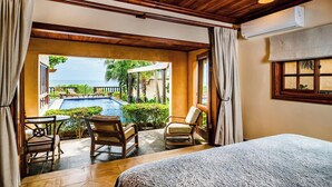 Ein Schlafzimmer mit Blick auf einen Pool und eine Sitzgelegenheit im Freien.