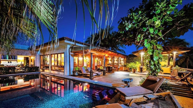 Ein Poolbereich im modernen Stil mit Liegestühlen und einer Bar.