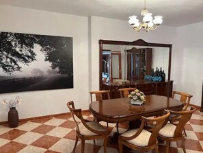 A dining room with a large wooden table surrounded by chairs, a chandelier, and a large mirror above the table. - big house with pool (La Victoria)